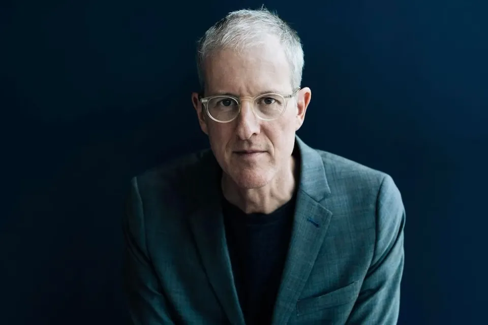 Headshot of Jeff Speck in grey suit against dark backdrop.